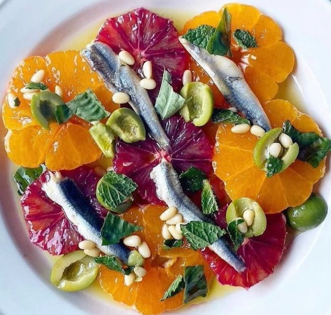 Anchois blancs sur rondelles d'orange sanguine, olives vertes et pignons