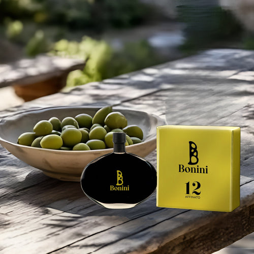 Bonini 12 Affinato 100 ml et son étui sur une table en bois sous les oliviers
